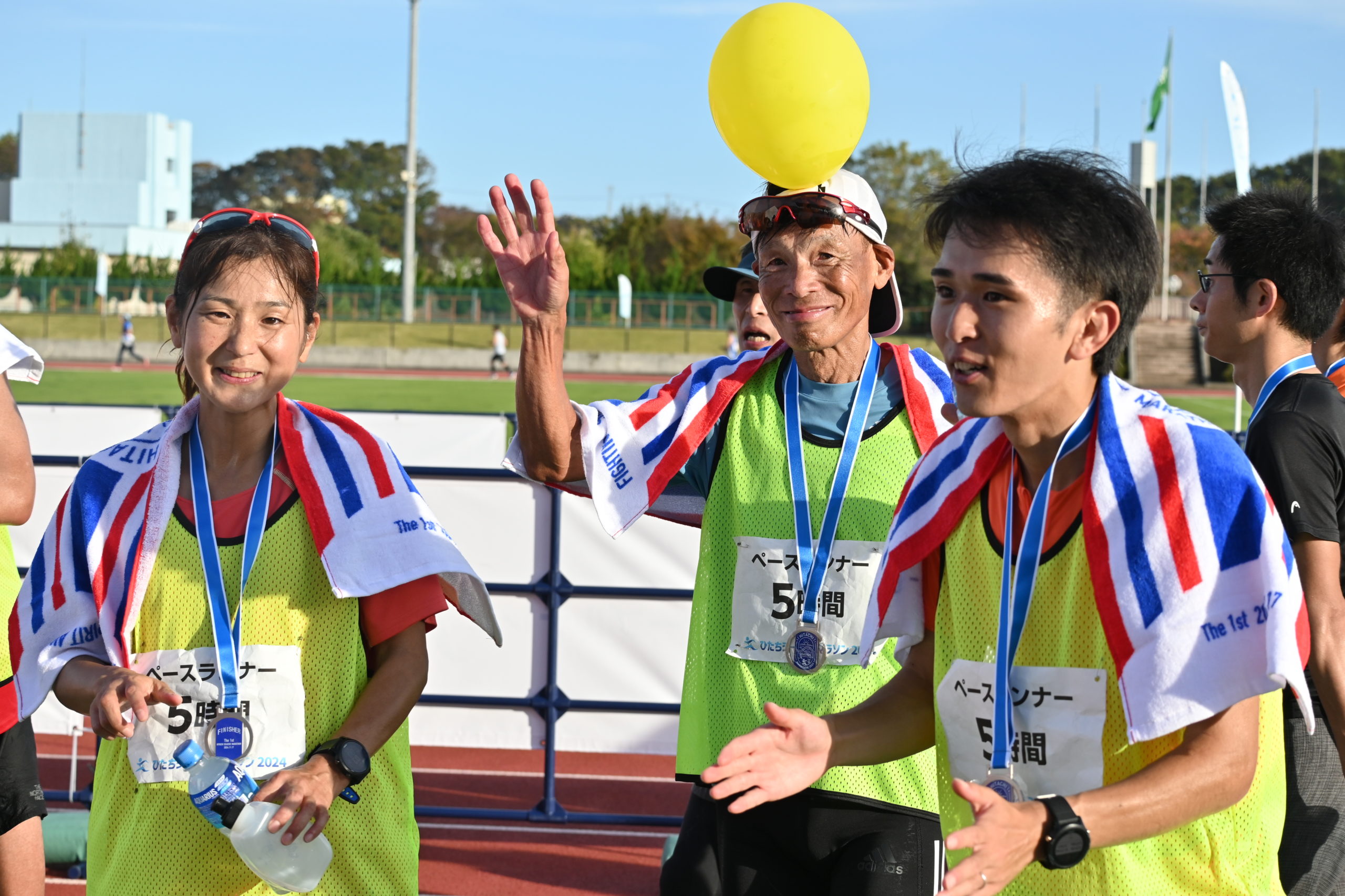 ５時間のペースランナーを務め、完走した吉田正さん（中央）＝日立市民運動公園陸上競技場