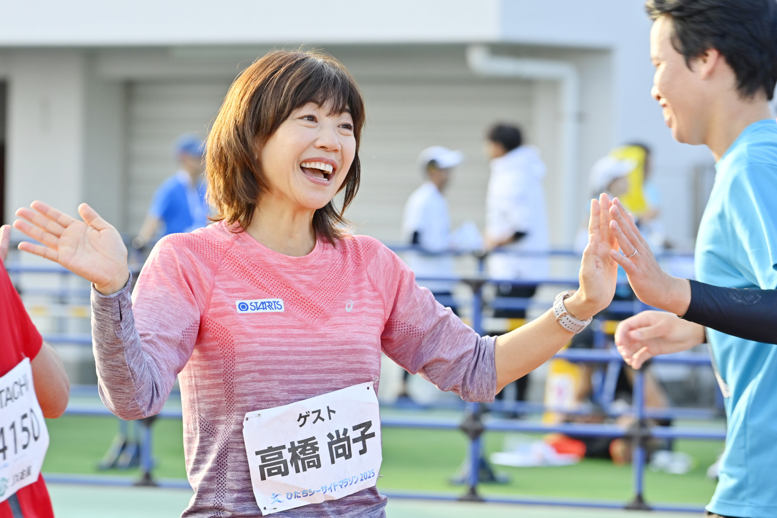 ゴール間際の選手に声をかけて元気づけるゲストの高橋尚子さん（左）＝日立市民運動公園陸上競技場